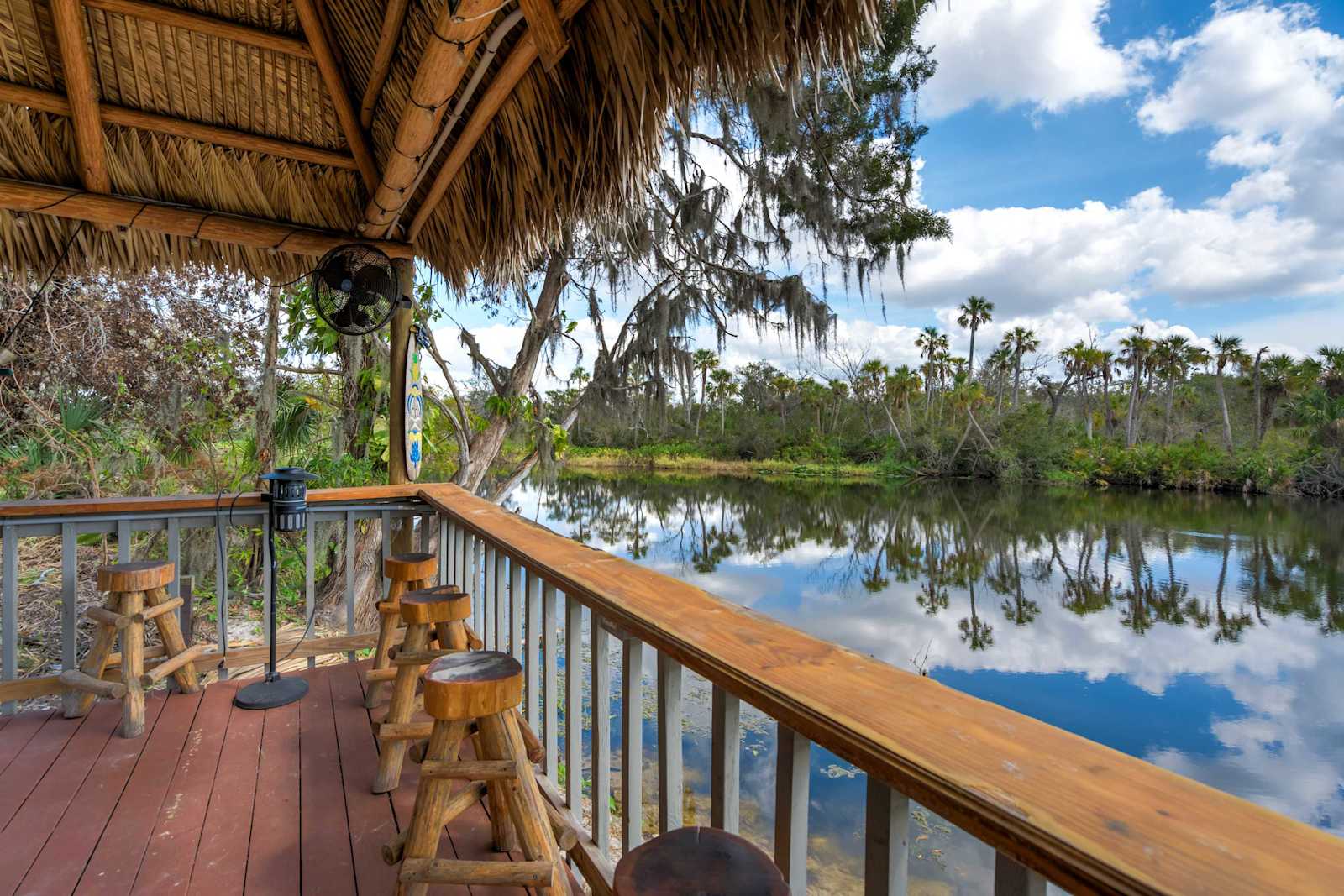 Welcome to Riverside Hut! Where you can relax at the tiki bar with breathtaking waterfront views, the perfect spot to soak in the peaceful surroundings..